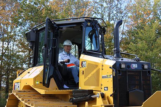 man with hard hat operating a bulldozer